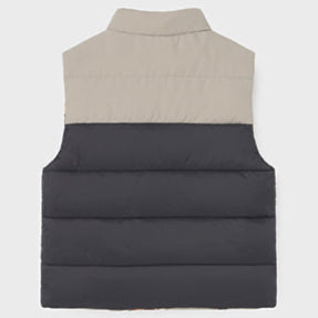 Two-tone puffer vest with beige top and black bottom on a light gray background