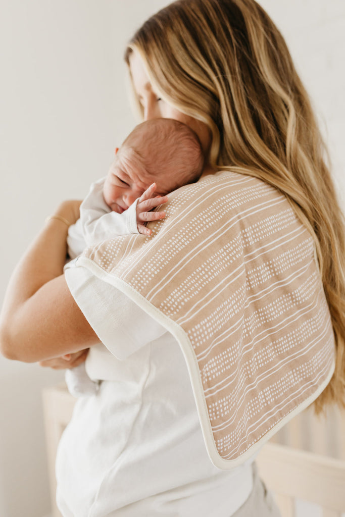Woman holding her newborn with the geometric pattern burp cloth